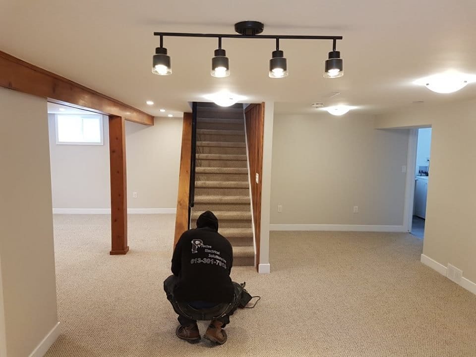 Electrician working in a freshly remodeled basement.