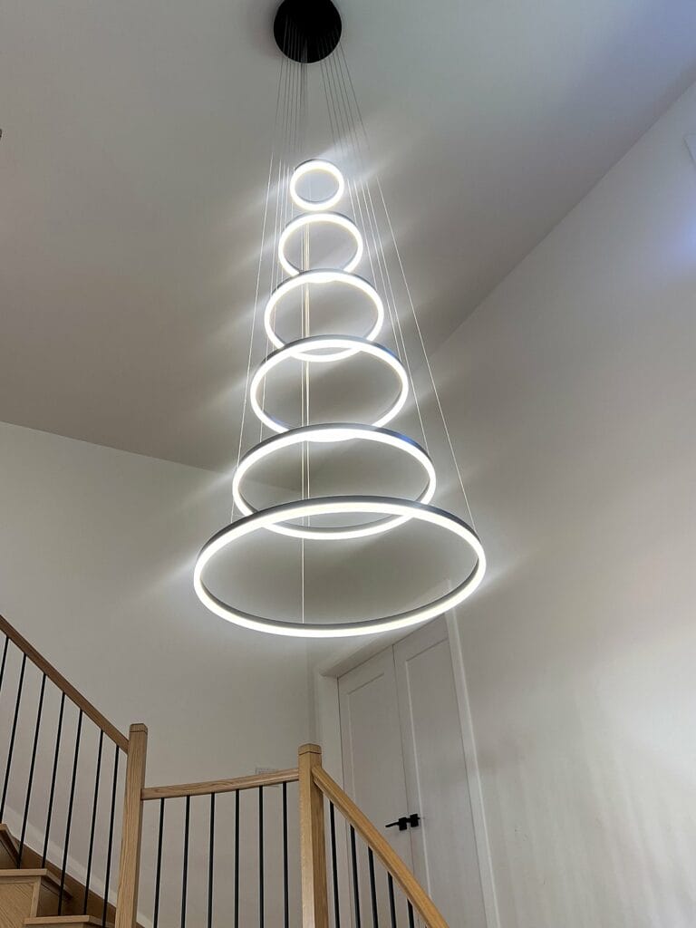Modern ring chandelier installed over a staircase