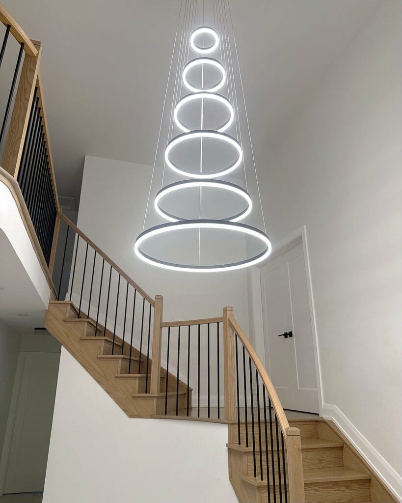 Tiered LED ring chandelier over a staircase, installed by Precise Electrical in Ottawa